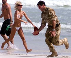 Soldatene fikk mer enn musikk: Geri Halliwell i et lekent øyeblikk på stranden i Oman sammen med vingkommandør Mark Smith. (Foto: AP)