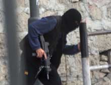 En palestinsk aktivist søker dekning under kraftige ildvekslinger mellom palestinske militante og israelske styrker i Betlehem i dag. (Foto: Scanpix/AP)
