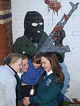 Flere skolejenter leker foran et IRA-veggbildet i Belfast 23. oktober 2001. (Foto: Scanpix/AP/Paul Faith) Flere skolejenter leker foran et IRA-veggbildet i Belfast 23. oktober 2001. (Foto: Scanpix/AP/Paul Faith)