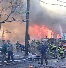 Brannmenn forsøker å få kontroll etter at det brøt ut brann i flere bygninger da flyet styrtet ved Queens. (Foto: Scanpix/AP/Fox 5) 
