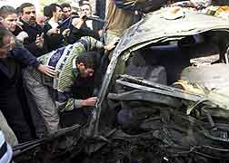 Palestinere samlet rundt den utbombede bilen. (Foto: AP/SCANPIX) 