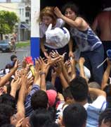 Sultne argentinere strekker hendene ut etter poser med mat fra en bil som blir plyndret(foto: ap/scanpix)