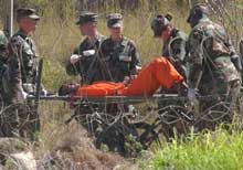 En fange ved den amerikanske Guantanamo-basen på Cuba bæres bort på båre. (Foto: Scanpix/AP/Lynne Sladky)
