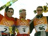 Frode Estil og Thomas Alsgaard flankerer juksemaker Mühlegg etter jaktstarten i OL.