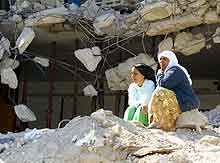 To palestinske kvinner sitter i ruinene av et ødelagt hus i flyktningleiren Jenin. Foto: Greg Baker, AP/Scanpix)