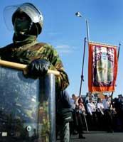 Fra Orange-ordenens parade gjennom Belfast i dag. Demonstranter passerer britisk soldat (Reuters)