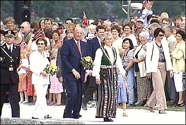 I 2002 var dronning Sonja og Kong Harald V i Balestrand. Ordfrar se Kari Einevoll gr fremst i bunad, og bakerst gr politimeister Kjell Ese. (Foto: Torje Bjellaas, NRK)