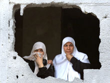 Palestinske kvinner ser ut gjennom et stort hull i veggen. (Foto: Scanpix/Reuters/Suhaib Salem)