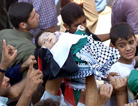 Palestinere bærer liket av en to måneder gammel baby som ble drept i angrepet natt til 23. juli i Gaza. (Foto: Suhaib Salem, Reuters)