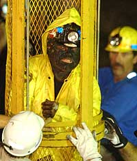 Den tredje av de ni gruvearbeiderne reddes ut ved hjelp av redningskapselen i morges. (Foto: Reuters/Guy Wathen)