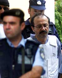 Greske Pavlos Serifis (høyre) forlater rettslokalet i Athen 25. juli 2002. Serifis var ifølge politiet involvert i drapet på CIA-stasjonssjefen Richard Welch i 1975. (Foto: Reuters/Yiorgos Karahalis)