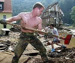 En tysk soldat spar bort gjørme i ruinene av et hus i landsbyen Wesenstein. Foto: Fabrizio Bensch, Reuters En tysk soldat spar bort gjørme i ruinene av et hus i landsbyen Wesenstein. Foto: Fabrizio Bensch, Reuters