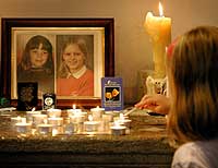 En ung jente tenner et lys for de to skolejentene Jessica Chapman og Holly Wells i kirken i Soham søndag 18. august 2002. (Foto: Reuters/Dan Chung) 