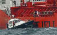 Franske sjøfartsmyndigheter på vei til den norske tankeren "Bow Eagle" for å gjøre sine undersøkelser. Foto: Scanpix/Reuters 