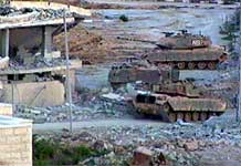 Israelske tanks har hakket løs på bygninger i Arafats hovedkvarter (Windows Media Audio).