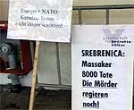 Milosevic ble møtt av demonstranter med plakater i Haag. 