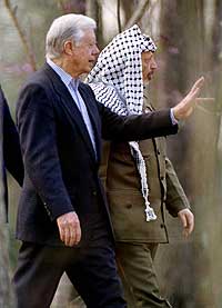 Fredsprisvinner Jimmy Carter viser frem hagen sin til palestinernes president Yasir Arafat 5. mars 1997. (Arkivfoto: Reuters/John Kuntz)