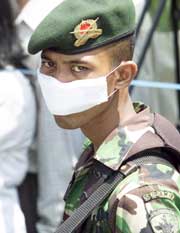 En soldat med munnbind utenfor et likhuset ved et av Balis sykehus. (Foto: Reuters/Darren Whiteside)