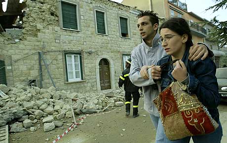 Et par løper i sikkerhet etter et nytt jordskjelv rammet San Giuliano di Puglia i Italia i ettermiddag. (Foto: Reuters/Vincenzo Pinto)