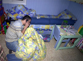 En fortvilet far på barnerommet der hans to barn ble skutt og drept. (Reuters-Scanpix)