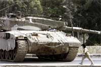 En palestinsk gutt passerer en israelsk tank som har gjenokkupert byen Nablus i dag tidlig. Foto: Scanpix/Reuters En palestinsk gutt passerer en israelsk tank som har gjenokkupert byen Nablus i dag tidlig. Foto: Scanpix/Reuters