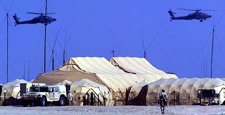 USA har allerede store styrker i nærheten av Irak. På bildet flyr to apache-helikoptre over flere militære telt i leiren 