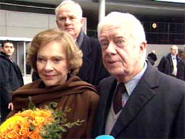 Jimmy Carter med seg sin kone Rosalynn under mottakelsen på Gardermoen i formiddag. I bakgrunnen direktør ved Nobelinstituttet, Geir Lundestad. Foto: NRK