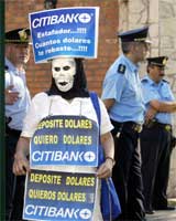 Maskert demonstrant krever pengene sine tilbake ( REUTERS/Enrique Marcarian) 