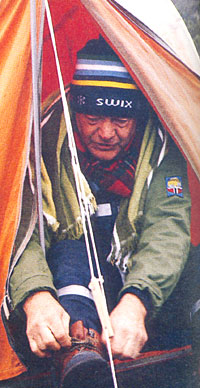 Tidlig morgen sittende i teltåpningen i P1-leiren i Tiklanika i Alaska knytter Rolf Kirkvaag skoene. Tidlig morgen sittende i teltåpningen i P1-leiren i Tiklanika i Alaska knytter Rolf Kirkvaag skoene.