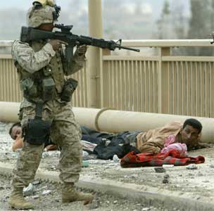 En amerikansk soldat holder irakiske soldater i sivile klær nede på bakken i en forstad til Bagdad. (Reuters/Oleg Popov)