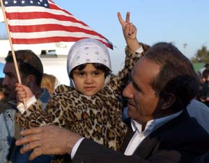 Eksil-irakeren Samr Ebrahim feirer Iraks nederlag med barnebarnet i Dearborn i USA sammen med 12.000 andre irakere i Michigan. (Foto: R. Cook, Reuters)