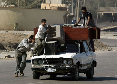 Alt som kan vere av verdi blir plyndra i Bagdad. Her har nokre ungdomar sikra seg ein fangst. (Reuters-foto)