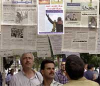 Syrere studerer aviser som gjengir USAs beskyldninger om at de samarbeider med Saddam Husseins regime (REUTERS/Khaled al-Hariri)