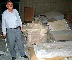 En av de ansatte ved nasjonalmuseet i Bagdad viser frem ødelagte antikviteter fra Mesopotamia. Foto: Kyodo, Reuters