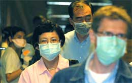 Flypassasjerer i Singapore bærer masker i et forsøk på å forhindre spredning av det dødelige viruset (foto: Getty Images)