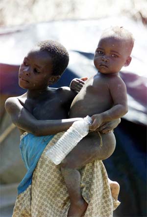 En ung kongolesisk jente tar vare på lillebroren sin på flukt fra kamphandlingene. (Foto: Reuters/Scanpix)