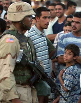 En amerikansk soldat patuljerer blant folkemengden i Bagdad. (Foto: Reuters/Scanpix)