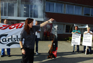 PROTESTERTE: Tou-ansatte protesterte mot Ringnes-ledelsen på bryggeriet i Stavanger onsdag morgen. Flere ansatte markerte sin avsky mot nedleggelsesplanene ved å brenne T-skjorter og annet Tou-utstyr. (Foto: Alf Ove Hansen / SCANPIX) 