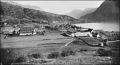 vre del av Stedje i 1880. Til venstre ligg Stedje kyrkje. I bakgrunnen er Sogndalsfjra. (Foto  Fylkesarkivet)