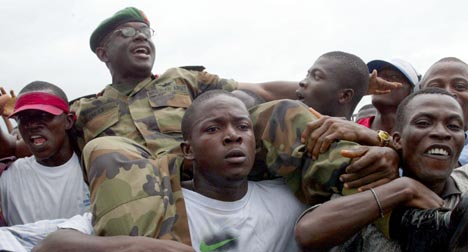 JUBEL: En liberiansk soldat blir båret på skuldrene ved ankomsten til Monrovia i dag (Foto: AP/ Scanpix).