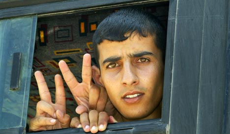 V-TEGNET: Palestinerne viste v-tegnet ut av bussvinduene da de ankom leiren i nærheten av Ramallah (Foto: AP/ Scanpix)