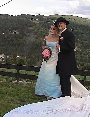 Brud og brudgom foran vakre omgivelser på Golsfjellet. Brudens kjole i isblått stoff med dekkmønster og rallynoter. Foto: Gunnar Grimstveit.