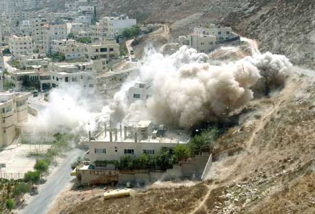 Røyken stiger opp fra ruinene av høyblokken som ble sprengt under jakten på en Hamas-leder (Scanpix/Reuters)