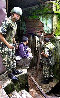Nepalske soldater undersøker en kontorbygning etter en av bombe-eksplosjonene i Katmandu (Foto: Scanpix). 