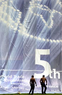 Arbeidere er klare til å heve WTO-møtets banner i Cancun i dag. (Foto: AP/Scanpix)