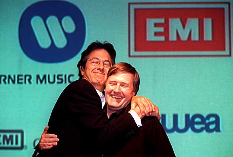 Roger Ames (venstre) var utpekt til sjef for det fusjonerte Time Warner EMI-selskapet med navnet Warner EMI Music. Her gir han Ken Berry en fusjonsklem. Berry var tiltenkt jobben som Ames høyre hånd. Bildet ble tatt da EMI og Time Warner presenterte sine f