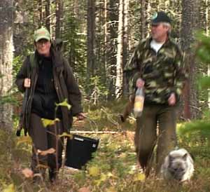 Anne-Birthe Aakrann Eek og Arild Halbakken med tissebøtte og tisseflaske i skogen.