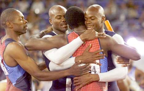 Calvin Harrison (t.h.) feirer OL-gullet på 4x400 meter sammen med Antonio Pettigrew, tvillingbroren Alvin Harrison og Michael Johnson. (Foto: AP/Scanpix)