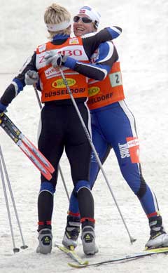 Marit Bjørgen og Hilde Gjermundshaug Pedersen omfavner hverandre etter seieren. (Foto: AFP/Scanpix)