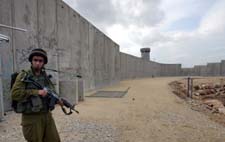 En israelsk soldat vokter muren mellom Israel og Vestbredden. (Foto: A. Qusini, Reuters)